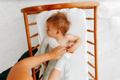 A mother putting her baby's transition swaddle on.
