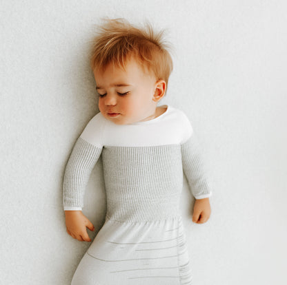 A small toddler in its arms out transition swaddle.
